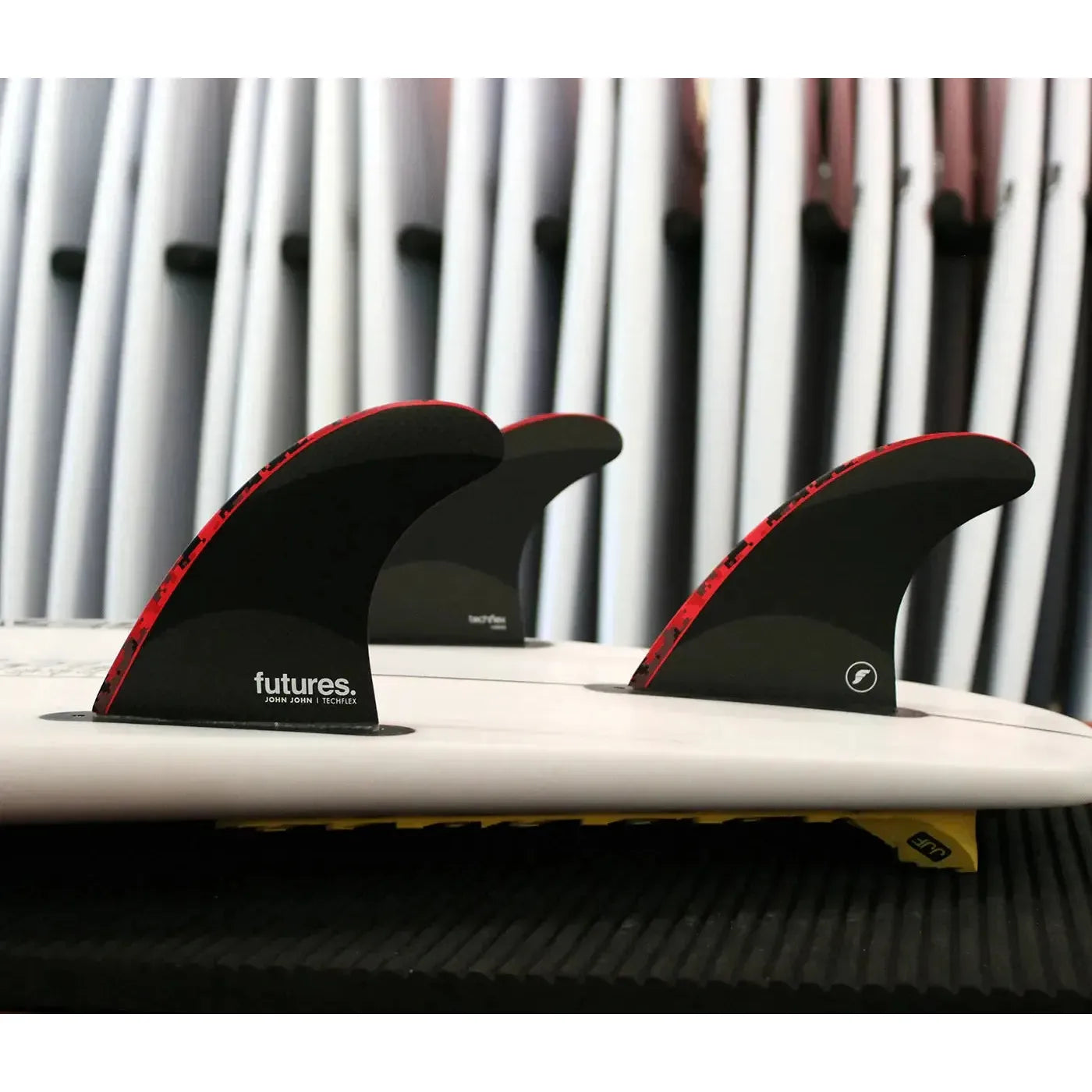 Board side shot of Futures John John Techflex Large Thruster Surfboard Fins | RED BLACK