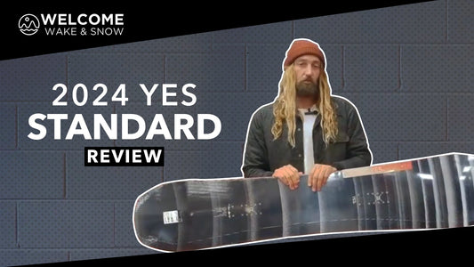 2024 YES Standard snowboard review at Welcome Boardstore, man holding snowboard indoors