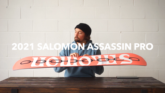 Man holding 2021 Salomon Assassin Pro snowboard at Welcome Boardstore for snowboarding gear review