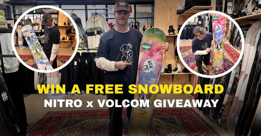 Man holding colorful Nitro x Volcom snowboard in Welcome Boardstore, snowboard giveaway promotion