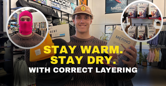 Man in Welcome Boardstore holding Merino base layers, Coal beanie; winter gear and baselayers display.