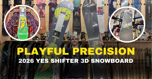 Man holding two YES Shifter 3D snowboards at Boardstore, surrounded by snowboard gear.