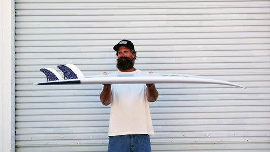 Channel Islands surfboard held side-on to show its thickness and rocker