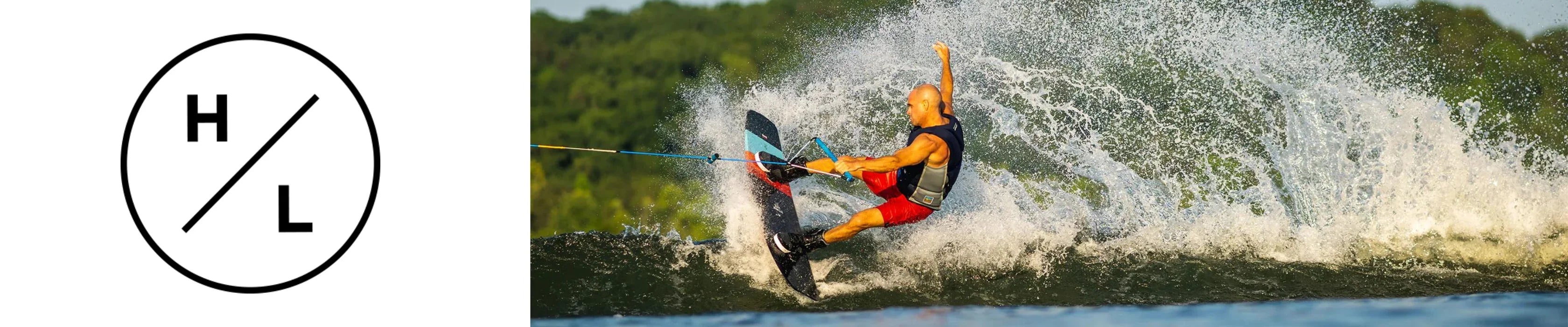 Wakeboarder in red shorts skimming water with splash, Hyperlite logo on left, summer setting