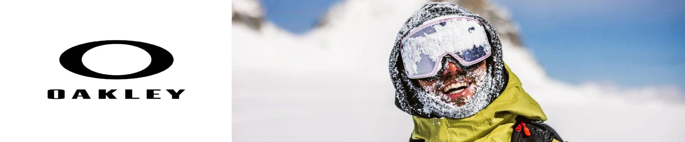 Oakley snow goggles on a smiling snowboarder with a snow-covered face and snowy mountain background