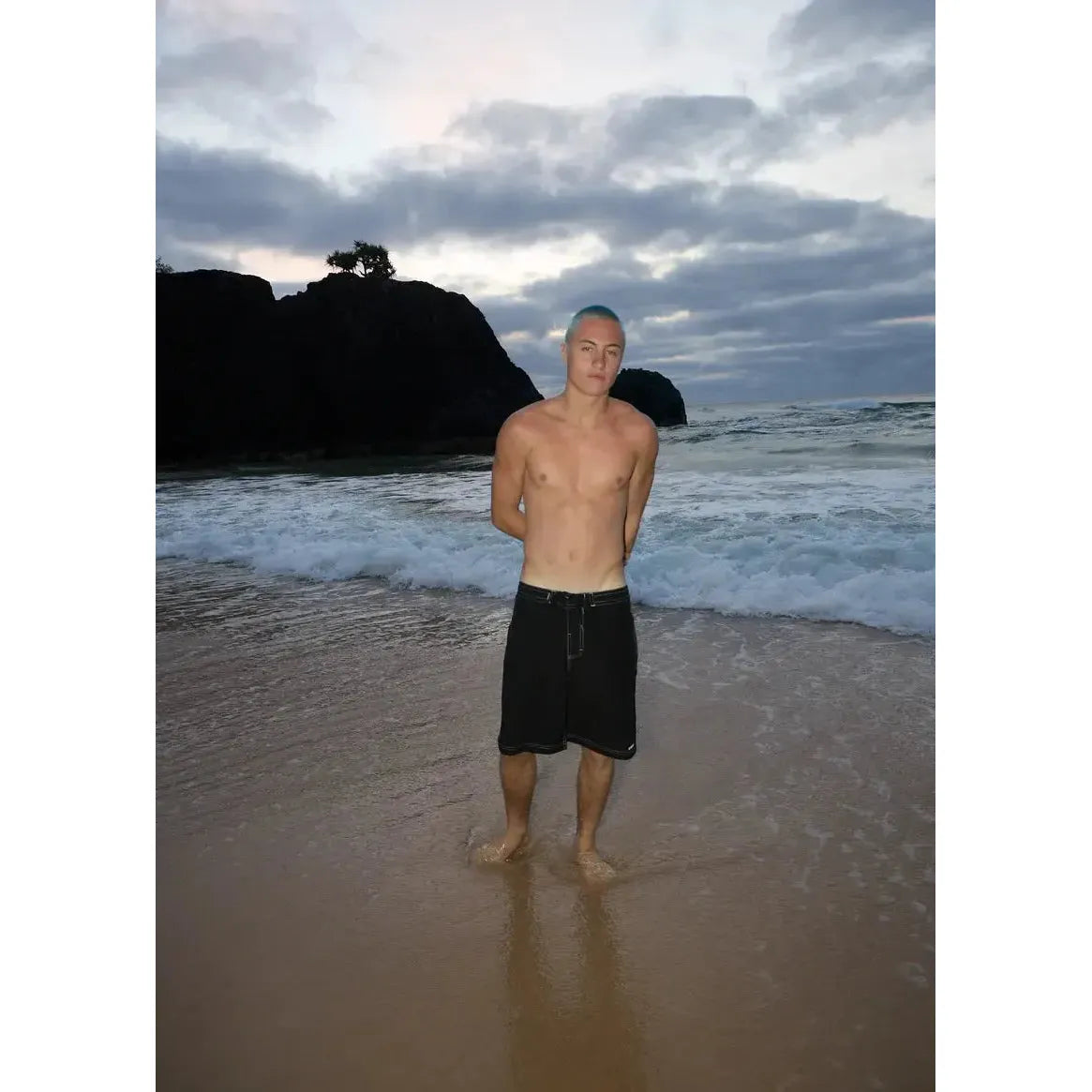 Summer time at the beach. Man wearing black shorts.