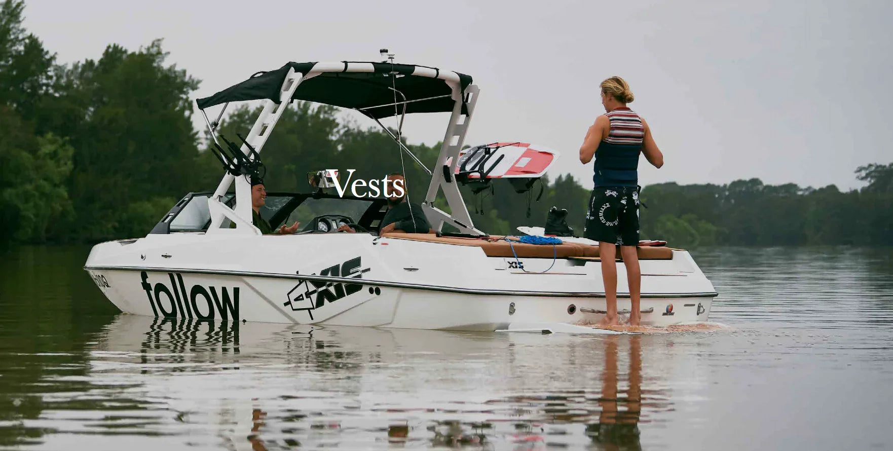 Wakeboarding vests displayed on a boat in calm water, outdoor wakeboard gear scene