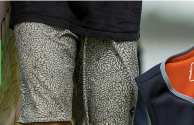 Patterned board shorts and surf vest, close-up, wakeboard and surf essentials