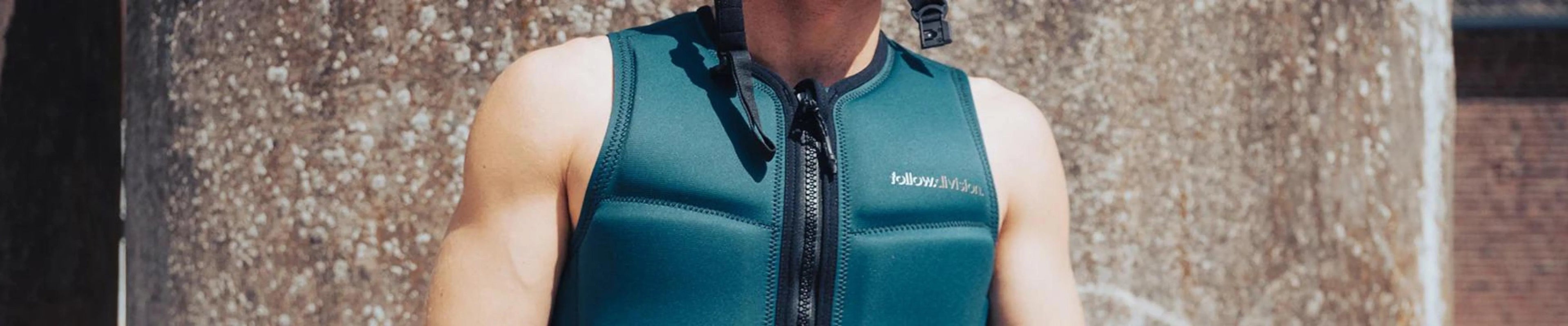 Wakeboarder wearing teal impact vest in sunlight, gear from Welcome Boardstore