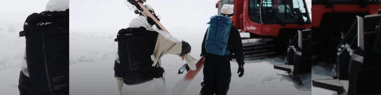 Snowboarders with backpacks walking in snowy landscape near snowcat vehicle