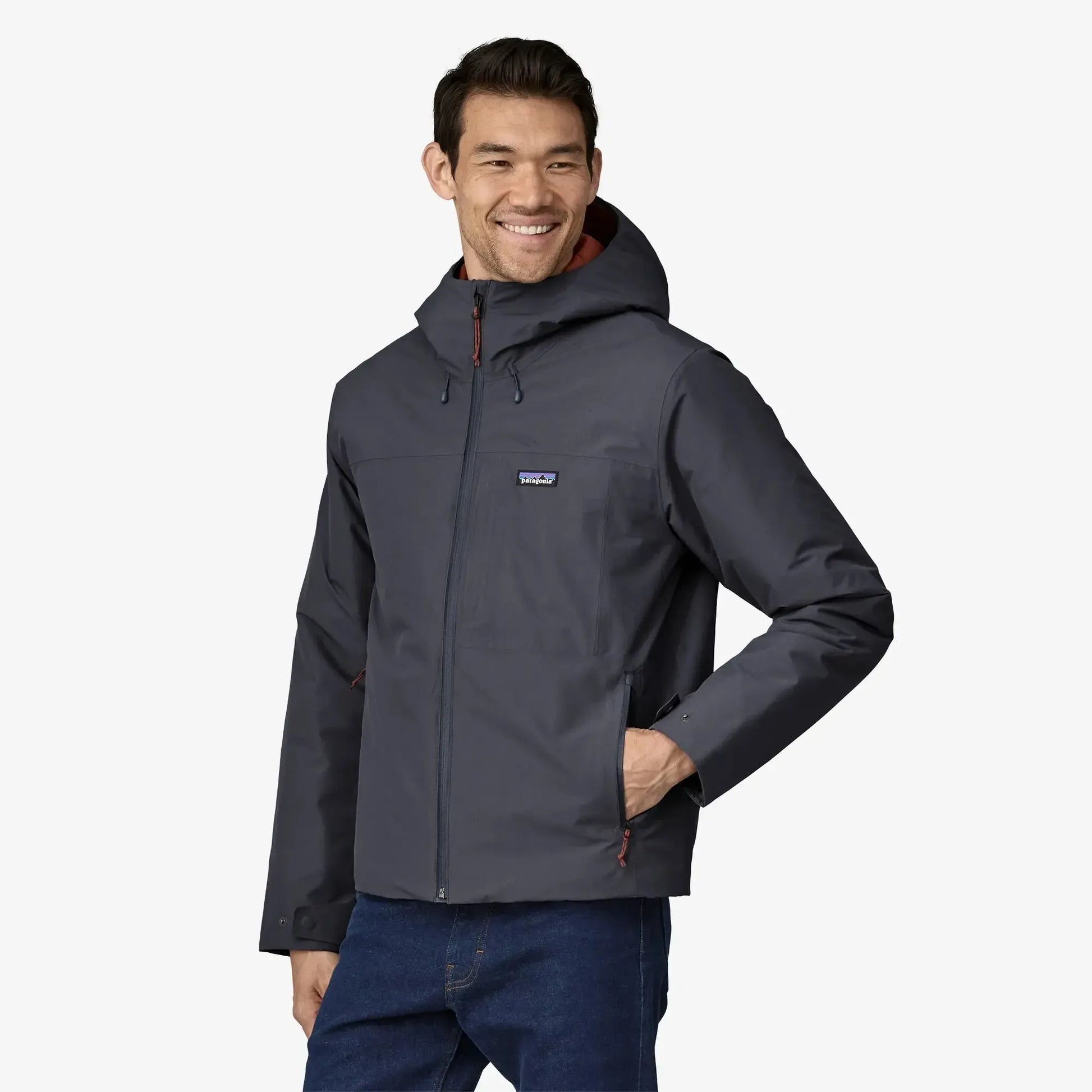Man wearing a gray jacket with a visible brand logo on a white background