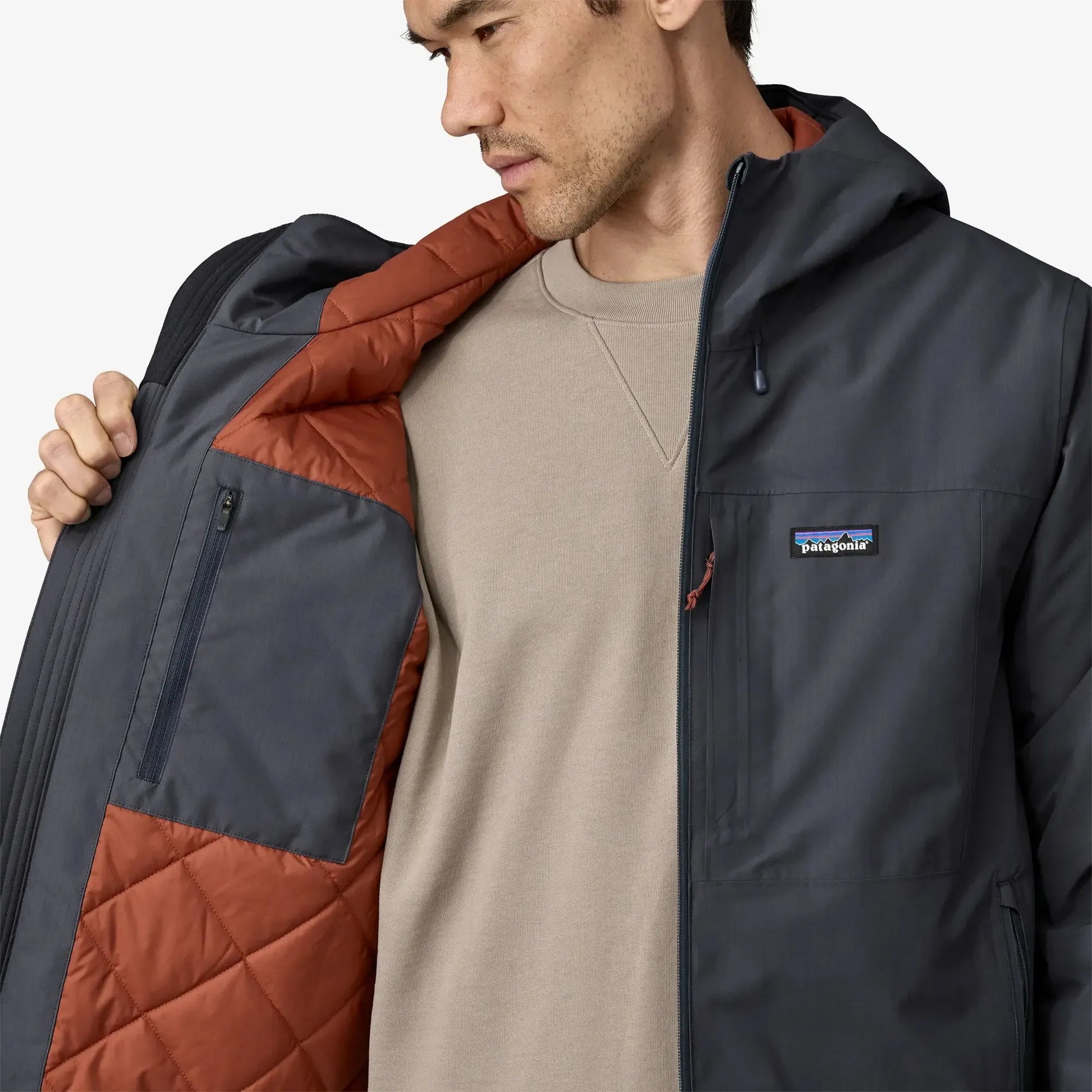 Man holding a Patagonia jacket with a neutral background