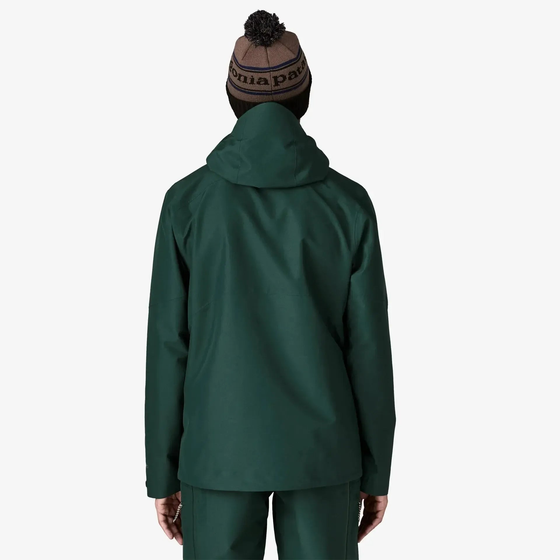 Person wearing a green jacket and pants with a beanie on a white background