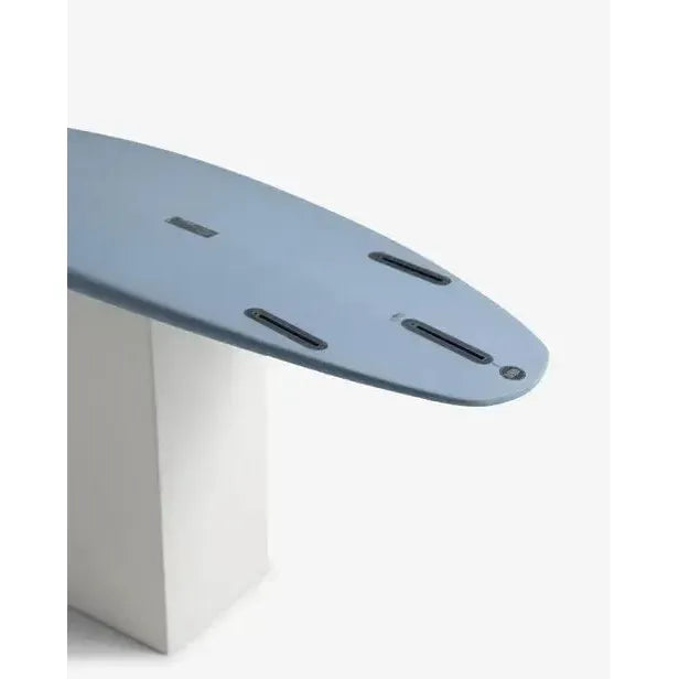 Blue surfboard tail with quad fin setup, displayed on white block, Welcome Boardstore