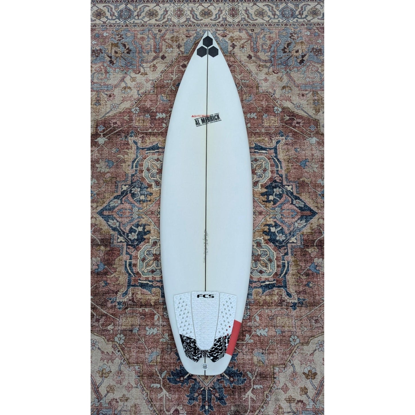 Surfboard on a patterned rug welcome board store top