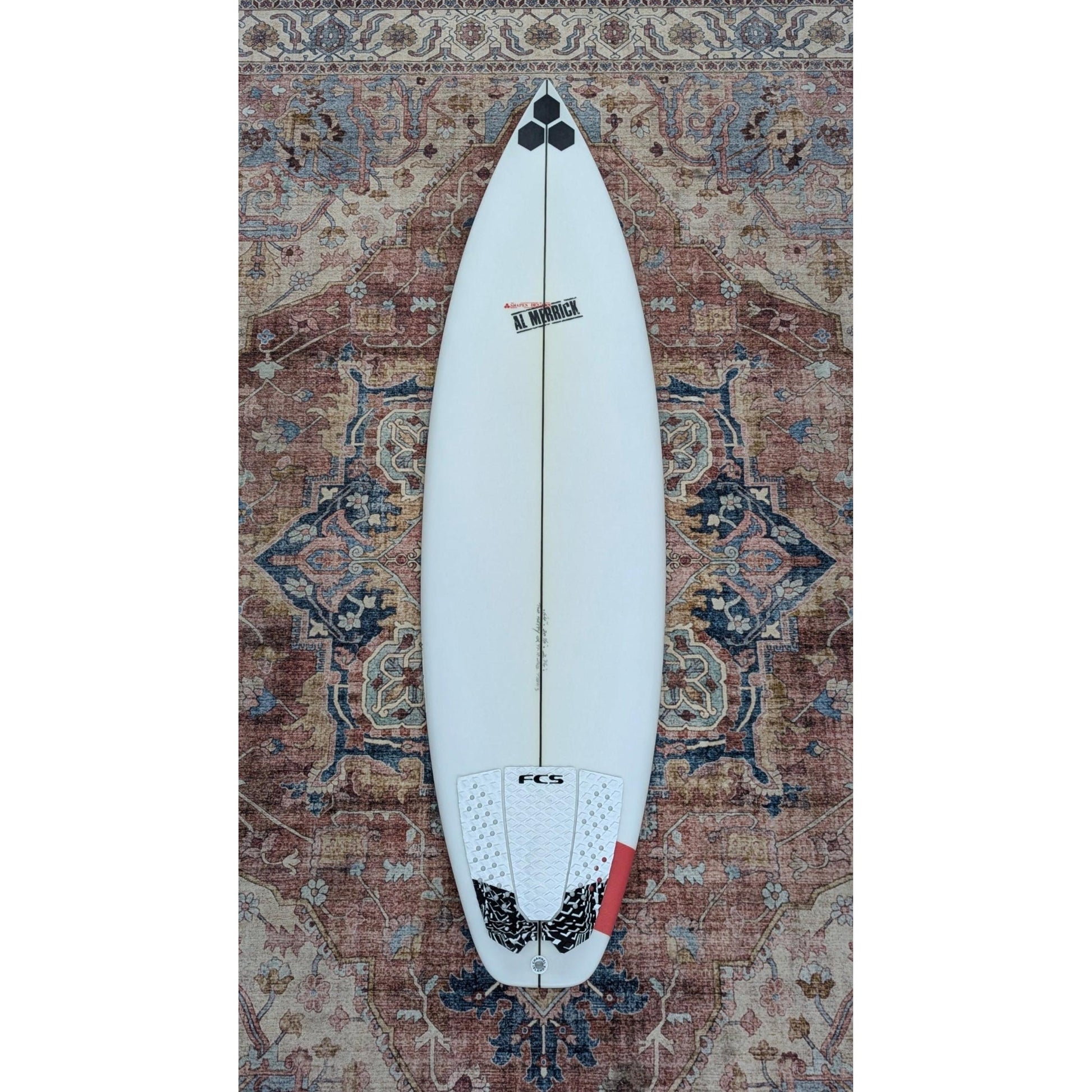 Surfboard on a patterned rug welcome board store top