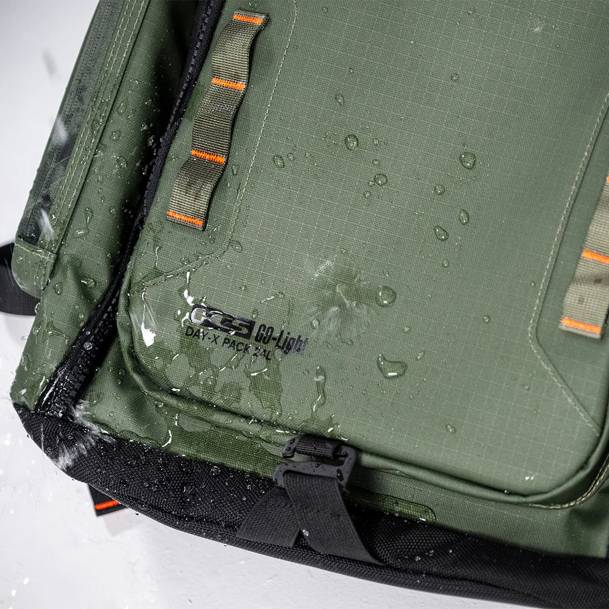 FCS Day X Pack 24L Green backpack with water droplets on a white background