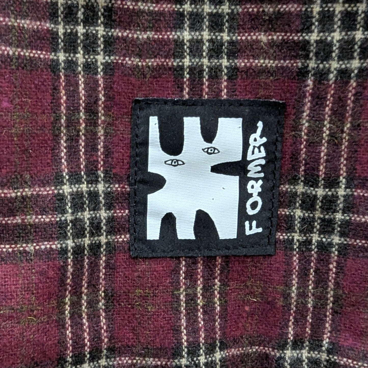 Plaid fabric with a 'Former' brand patch in the center welcome boardstore