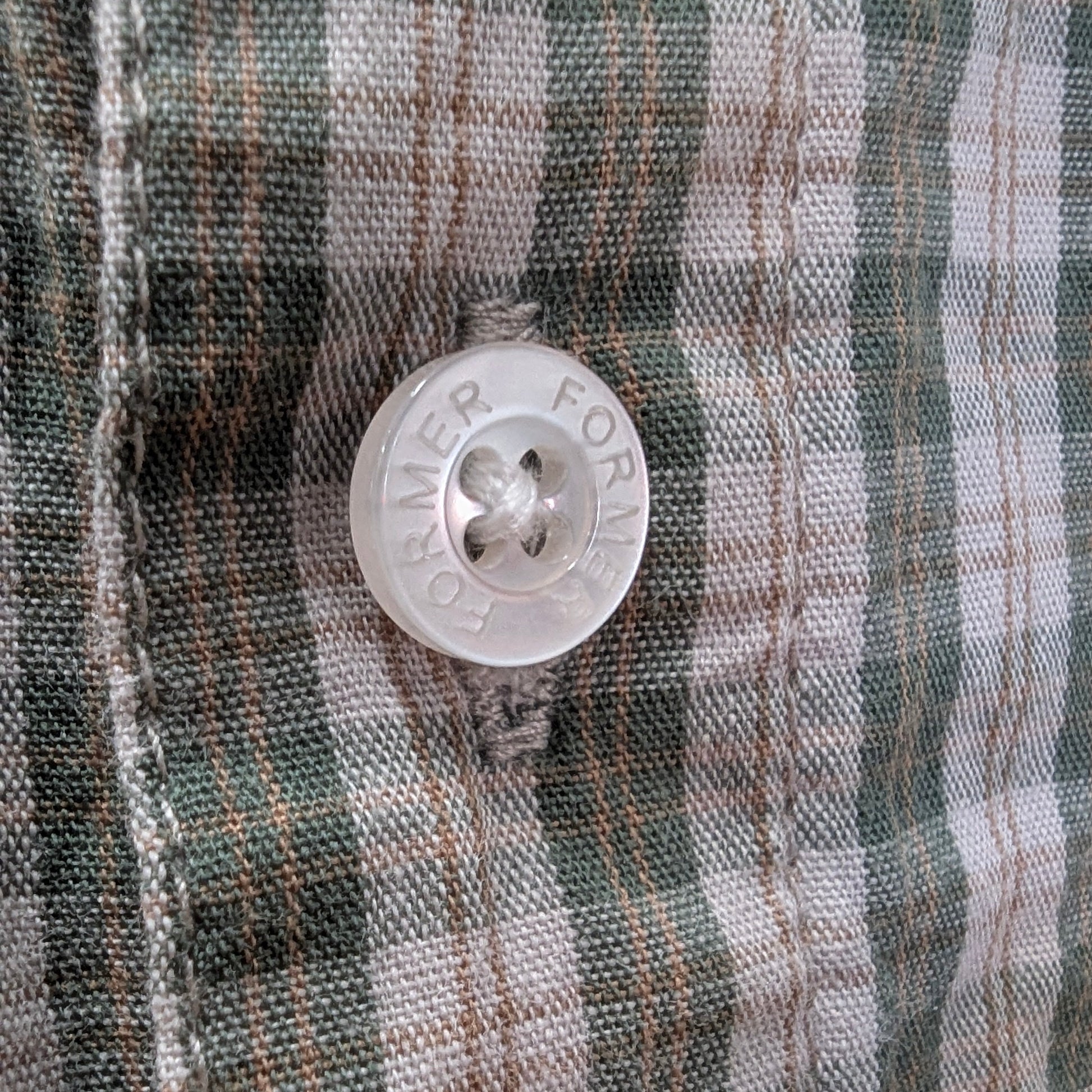 Close-up of a button on plaid fabric welcome boardstore