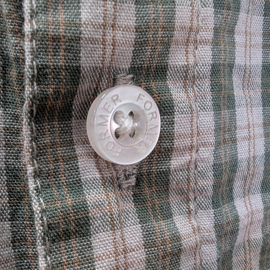 Close-up of a button on plaid fabric welcome boardstore