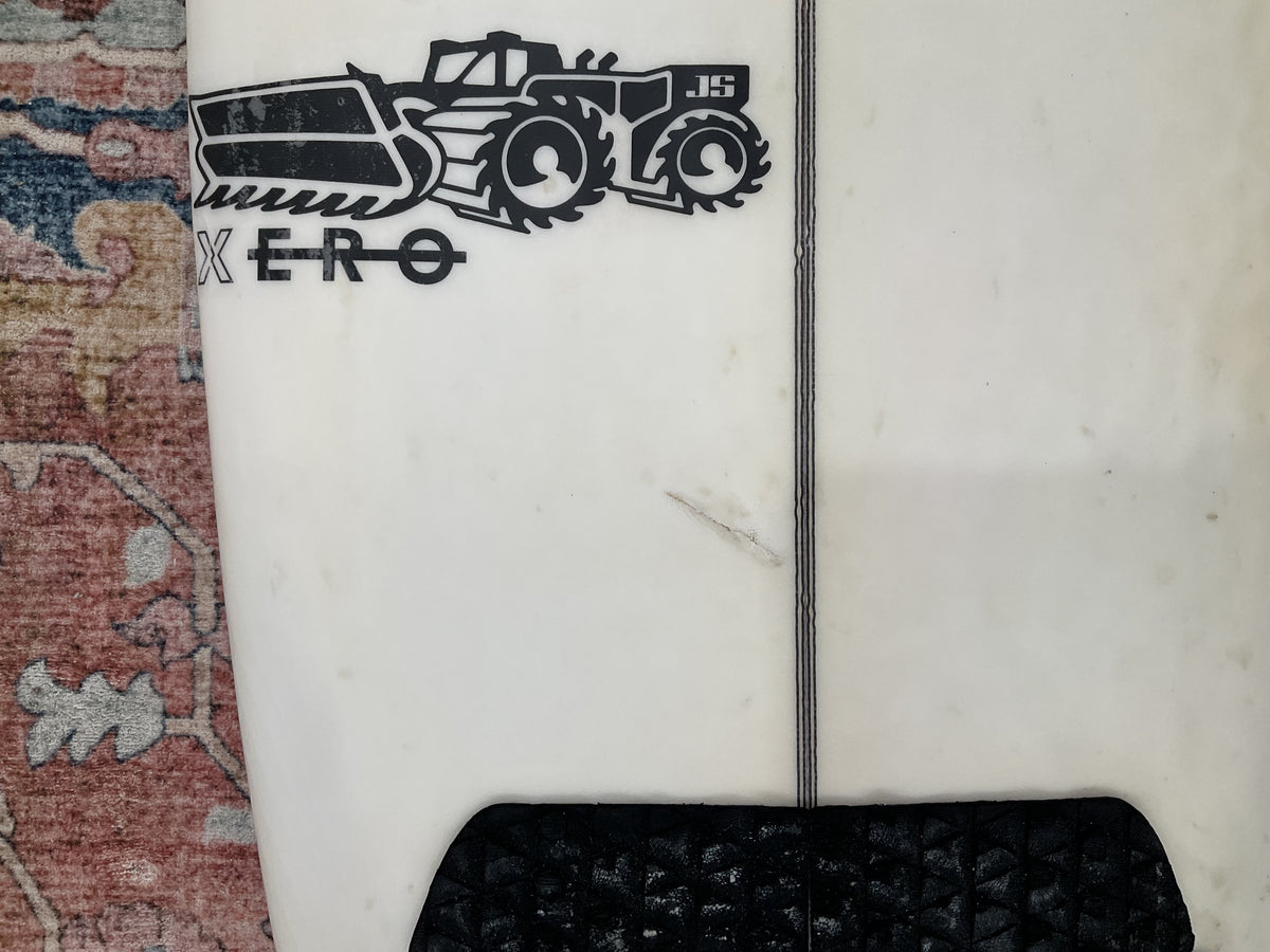 Close-up of JS Industries Xero logo on the deck of a white pre-loved surfboard