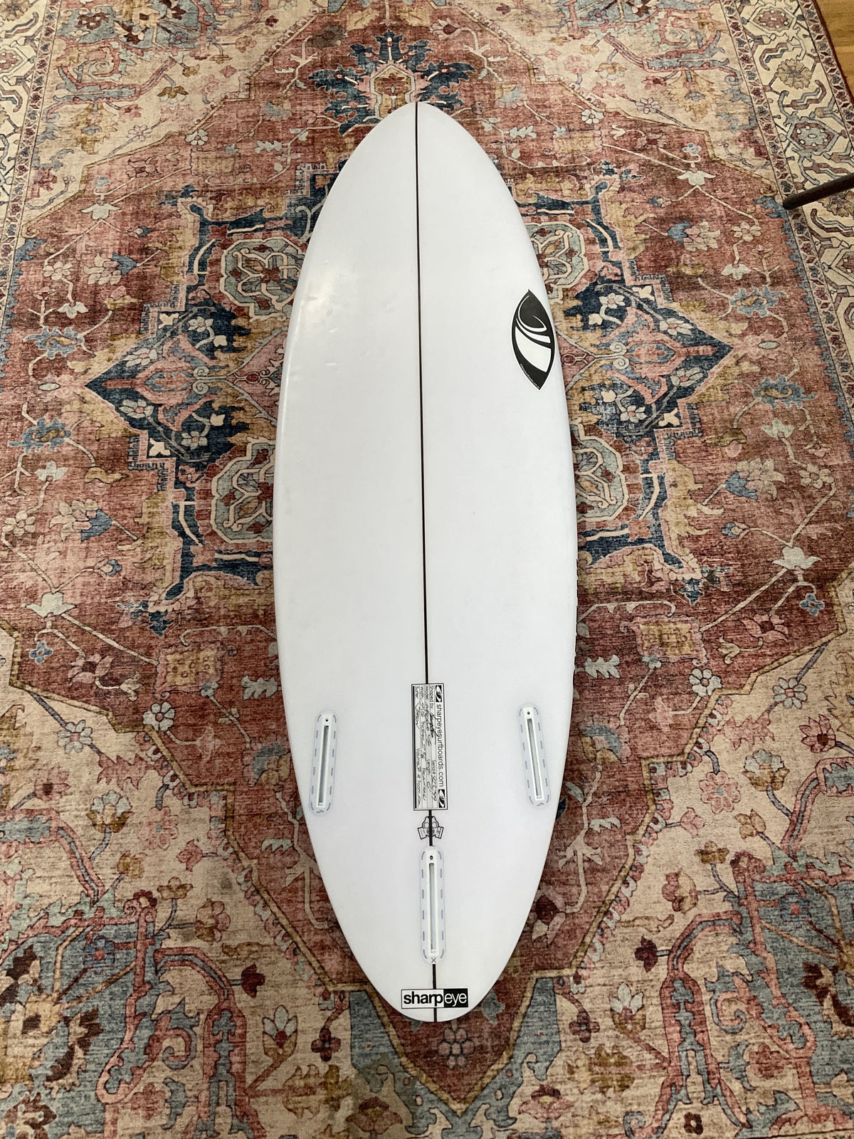 Bottom of white Sharpeye Inferno 72 pre-loved surfboard with Futures thruster fin boxes