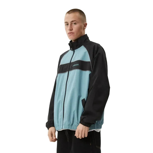 Person wearing a black and light blue jacket with a brand logo on a white background