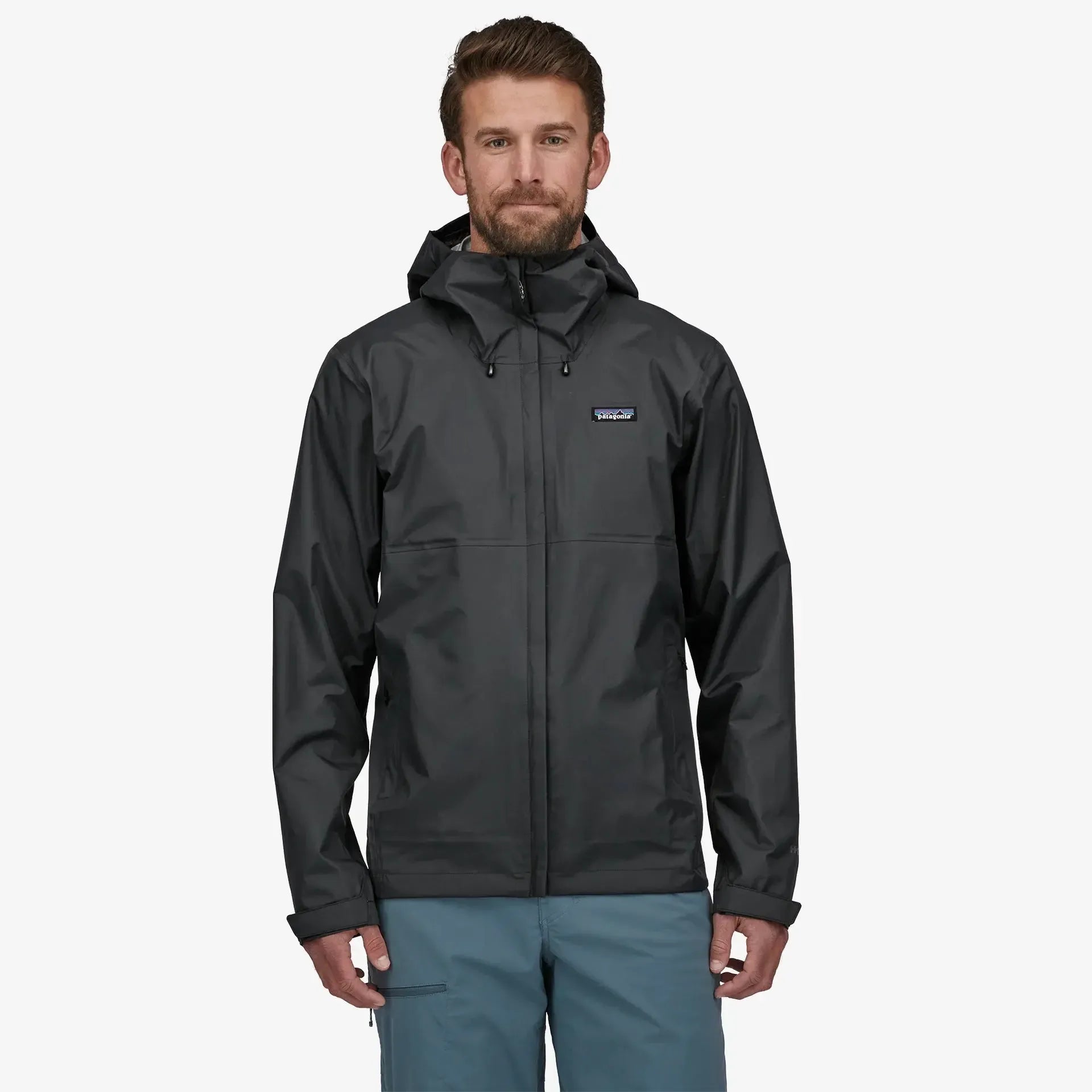 Man wearing a black rain jacket with a visible brand logo on a white background