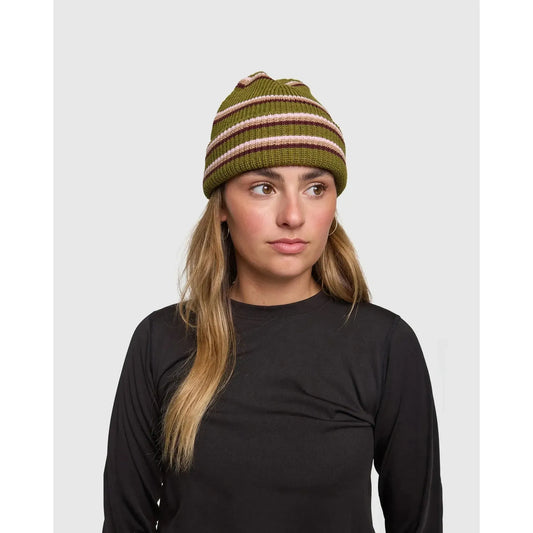 Woman wearing a green and pink striped beanie against a plain background