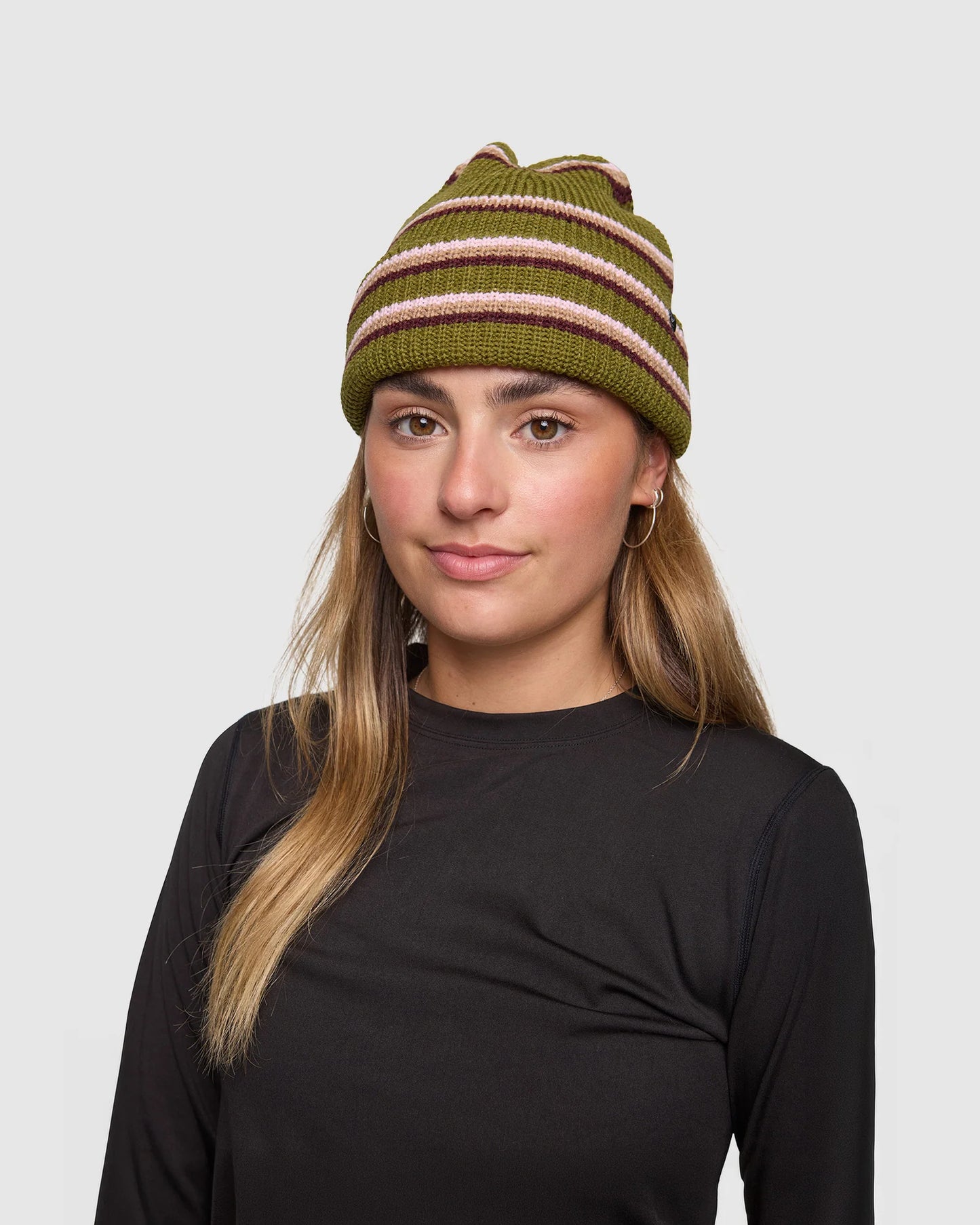 Person wearing a green striped beanie on a plain background