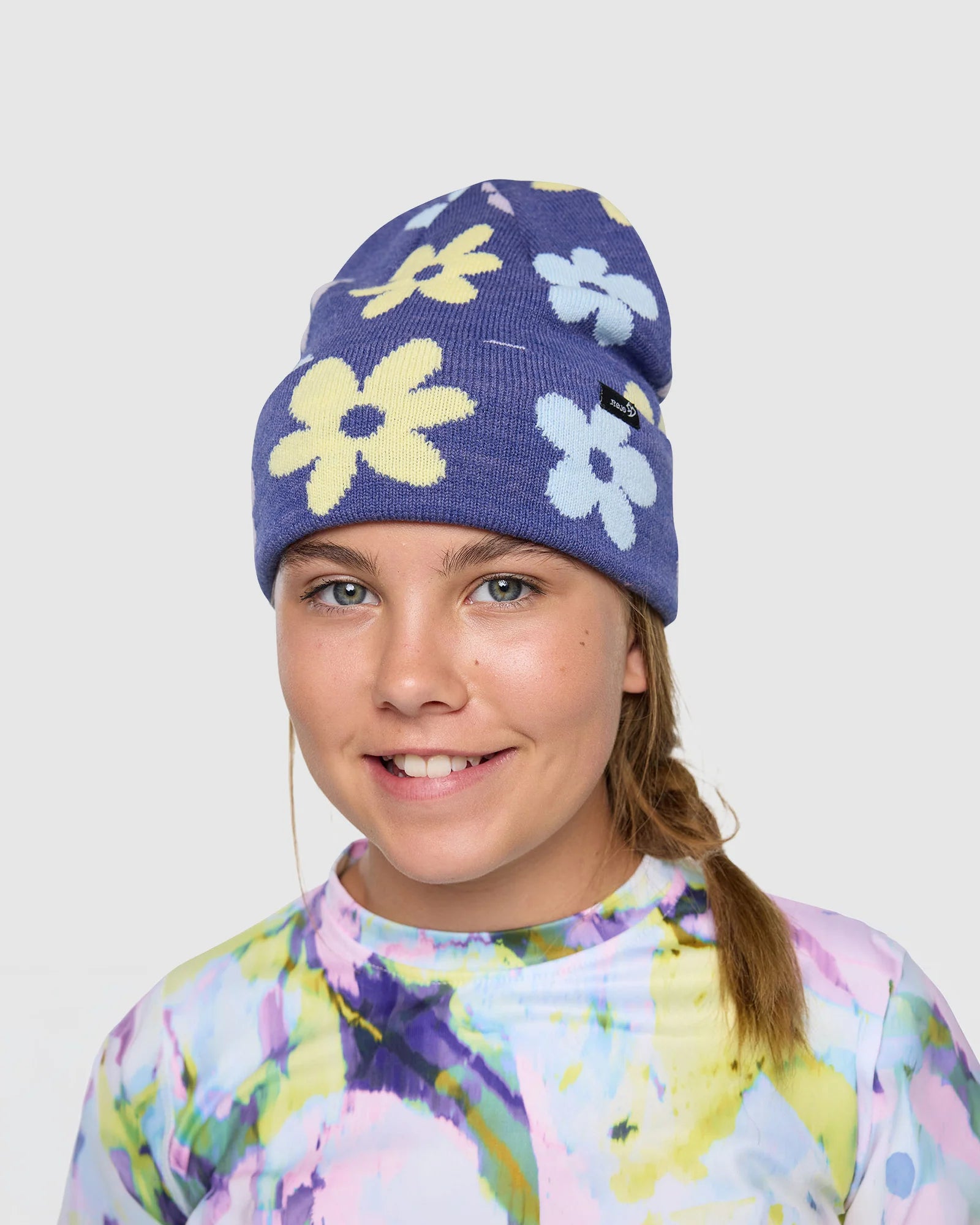 Rojo Spring Bloom Beanie Person wearing a colorful floral-patterned beanie on a plain background