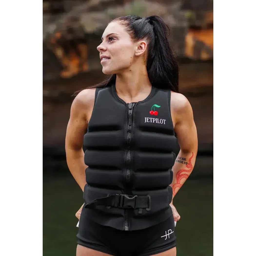 Woman wearing black Jetpilot wakeboard vest outdoors, ideal for wakeboarding or water sports
