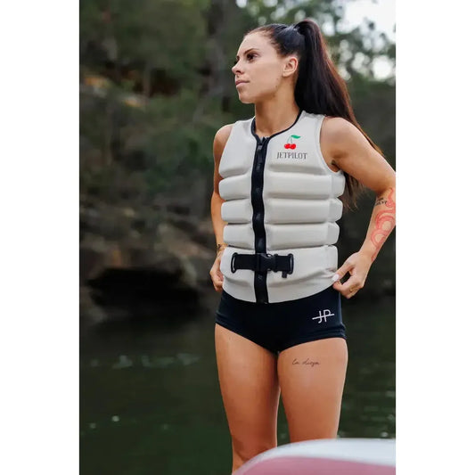 Woman wearing Jetpilot off-white wakeboard vest outdoors near water, ready for water sports