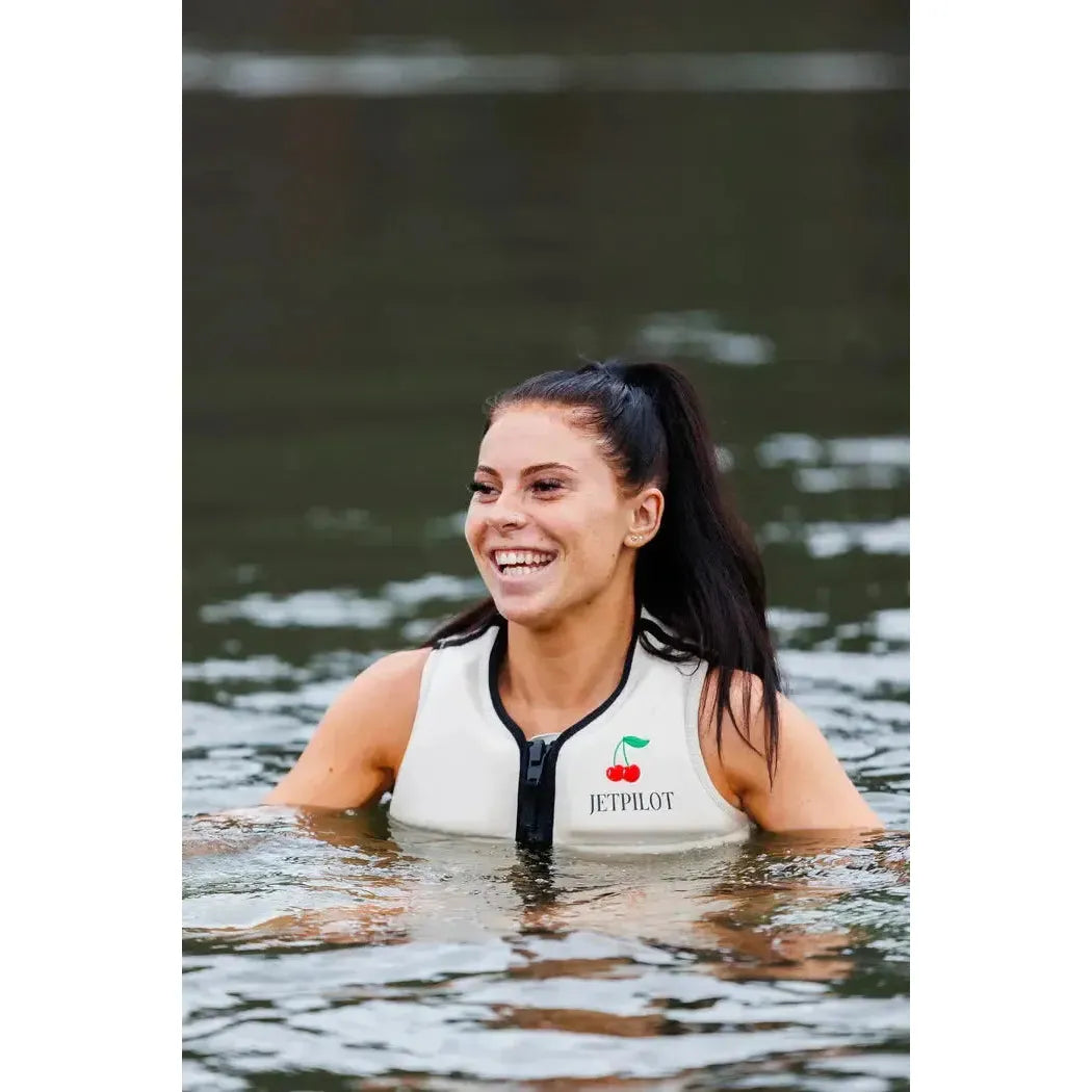Woman in off-white Jetpilot life vest smiling in water, wakeboarding essentials lifestyle